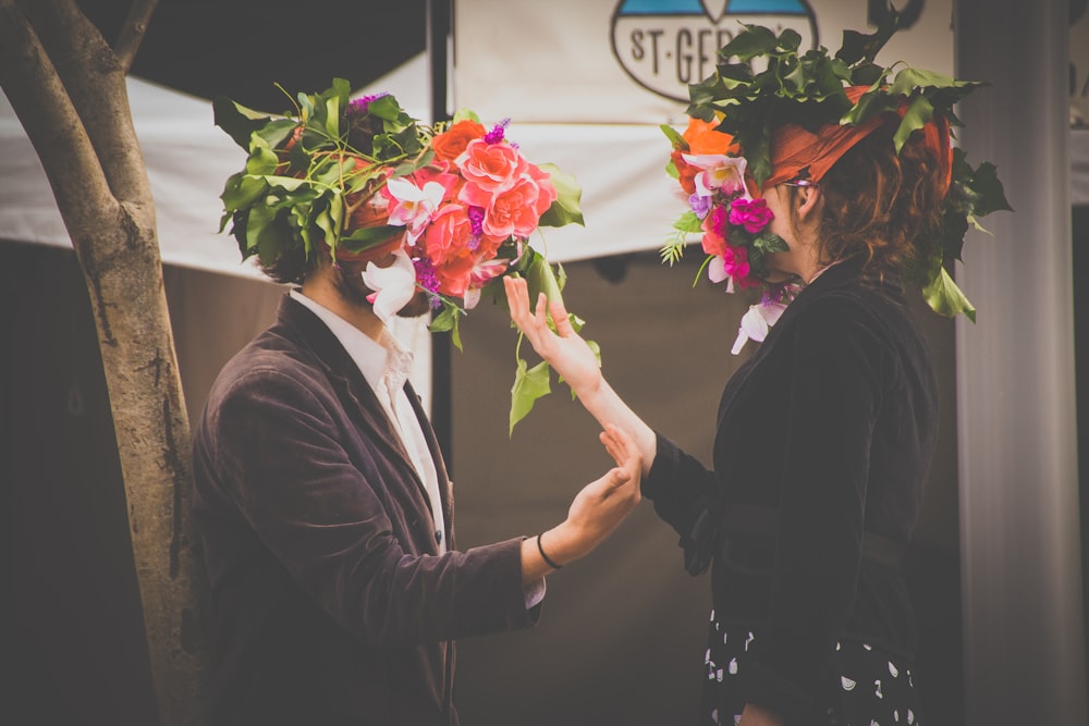 hombre y mujer sosteniendo flores