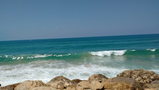 A serene ocean scene with waves crashing against rocks.