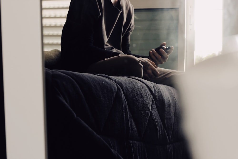 a man sitting on a couch using a cell phone