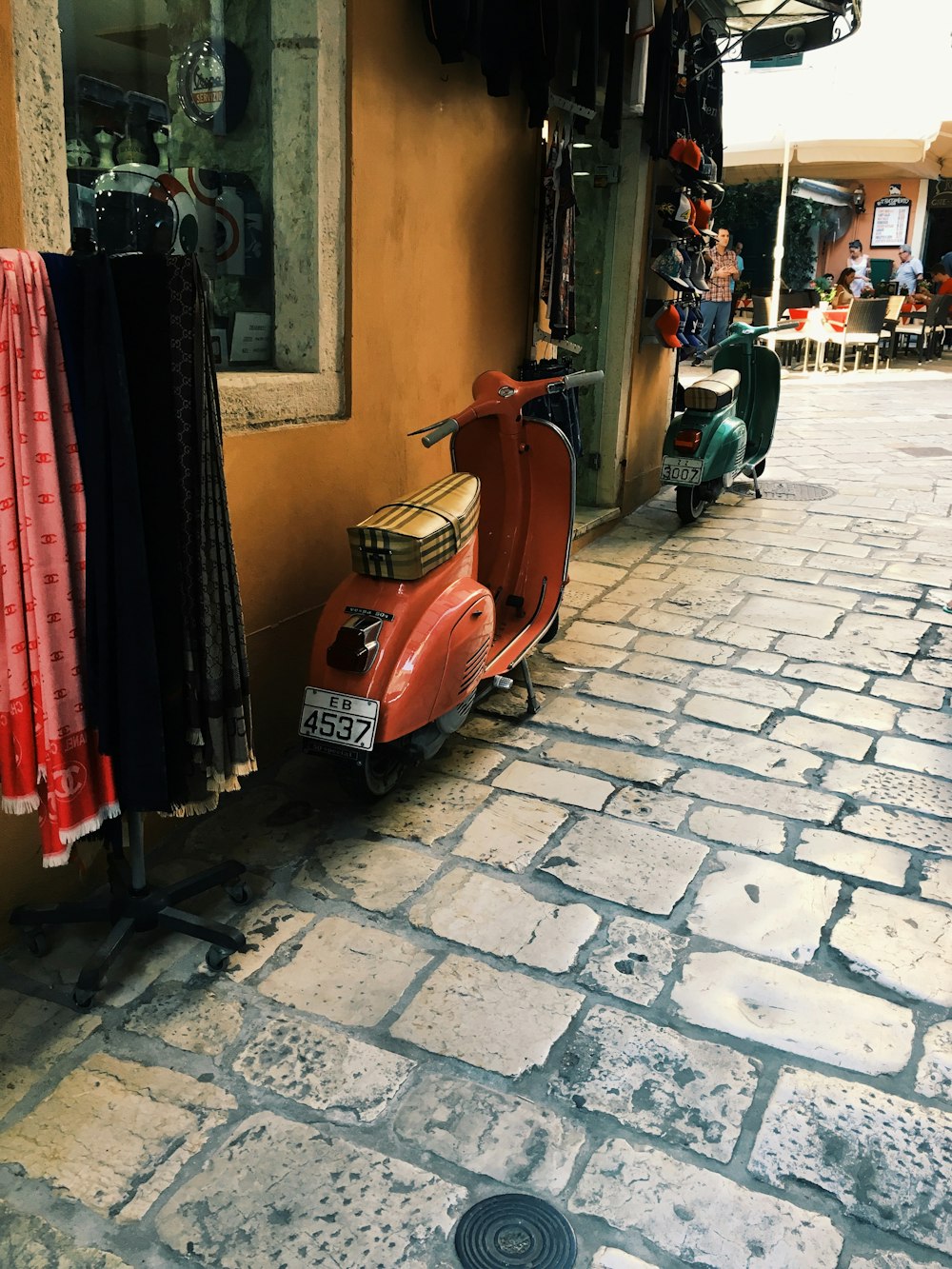 a red scooter parked on the side of a building