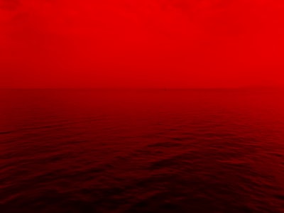 photo of ocean with red lights red teams background