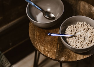 one gray bowl with cereal and one empty bowl