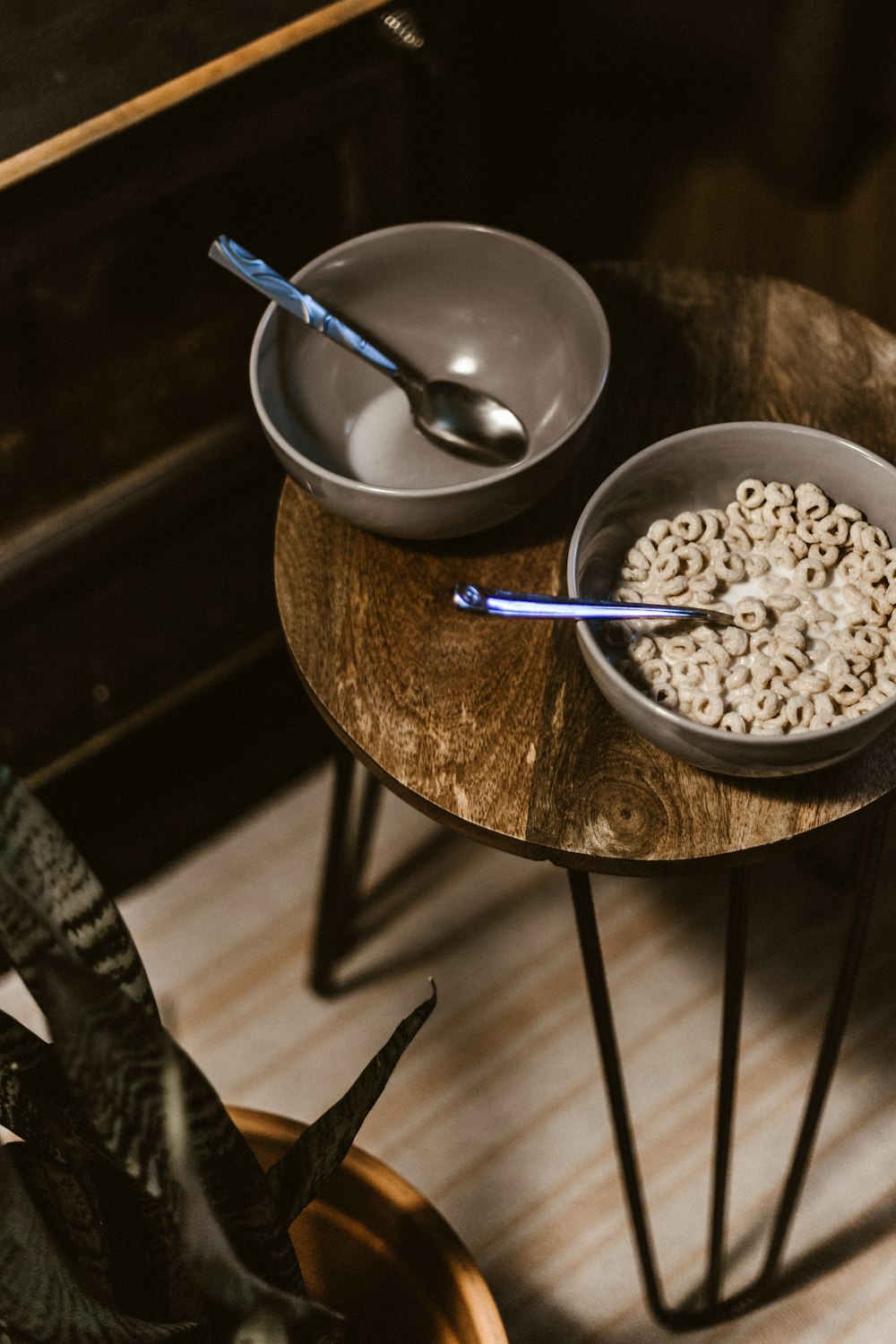 one gray bowl with cereal and one empty bowl