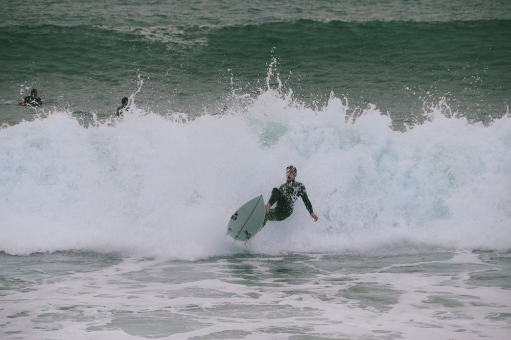 Uomo che fa surf sull'oceano verde durante il giorno