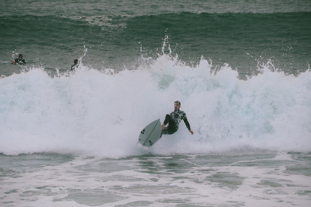 man surfing on green ocean during daytime