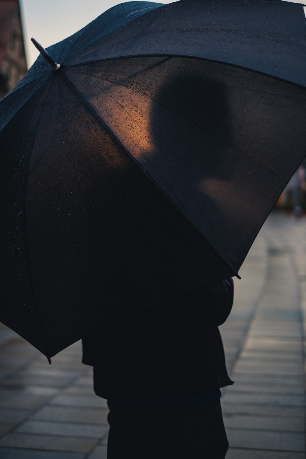pessoa segurando guarda-chuva preto
