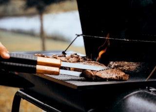 person grilling meat outdoors