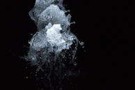 A dynamic splash of paint captured mid-air against a dark background.
