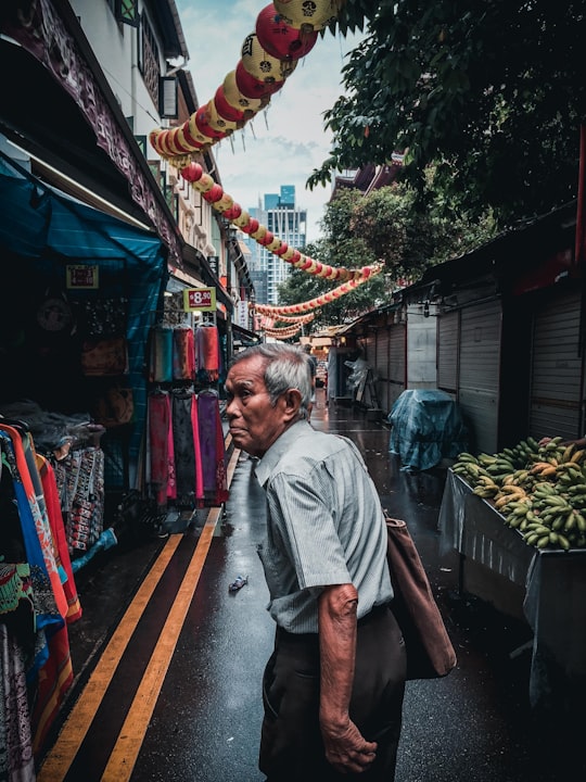 man walking on alley with stores in Chinatown Singapore Singapore