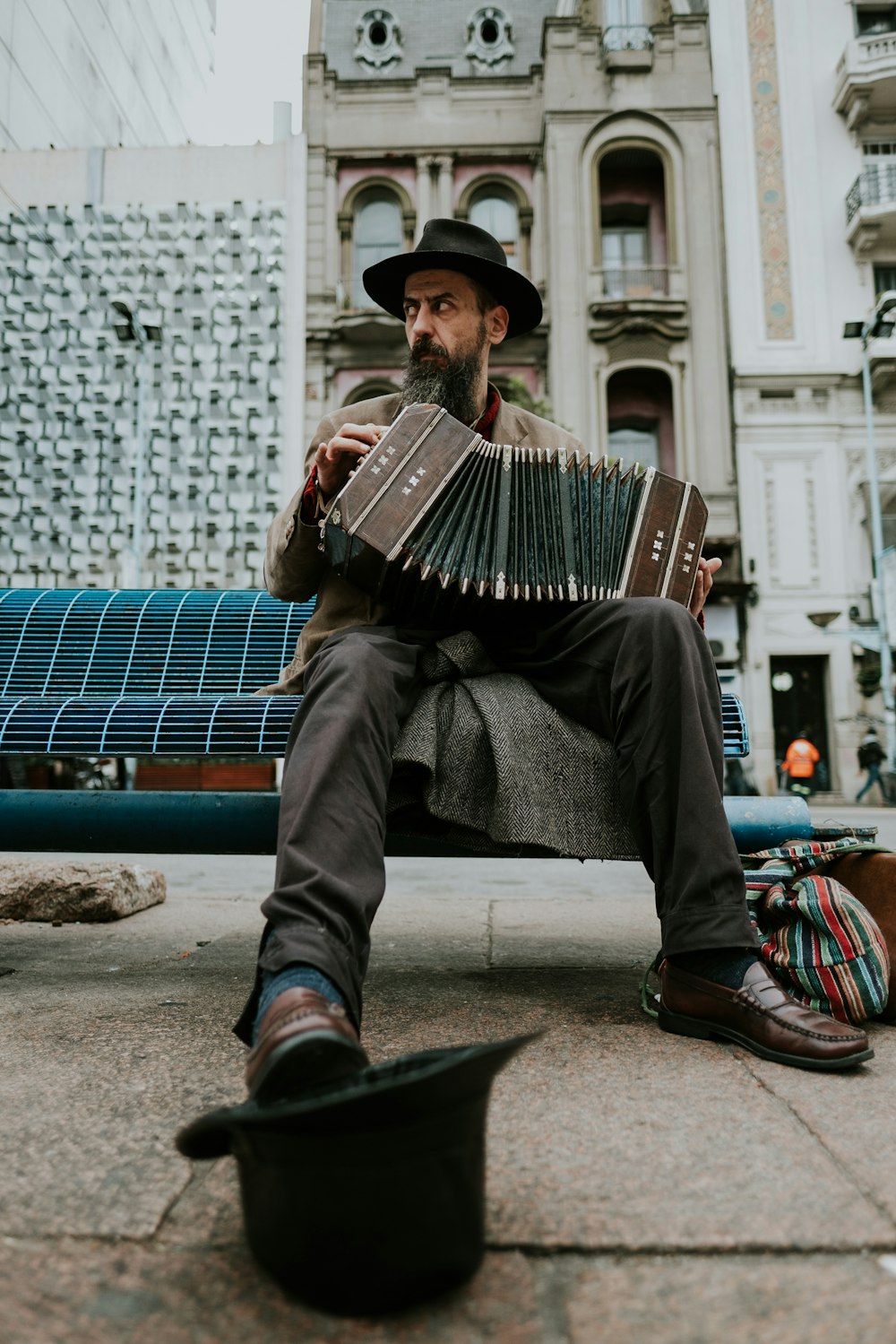 man sitting on bench playing accordion
