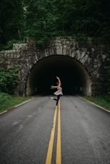woman in ballet position nearby tunnel