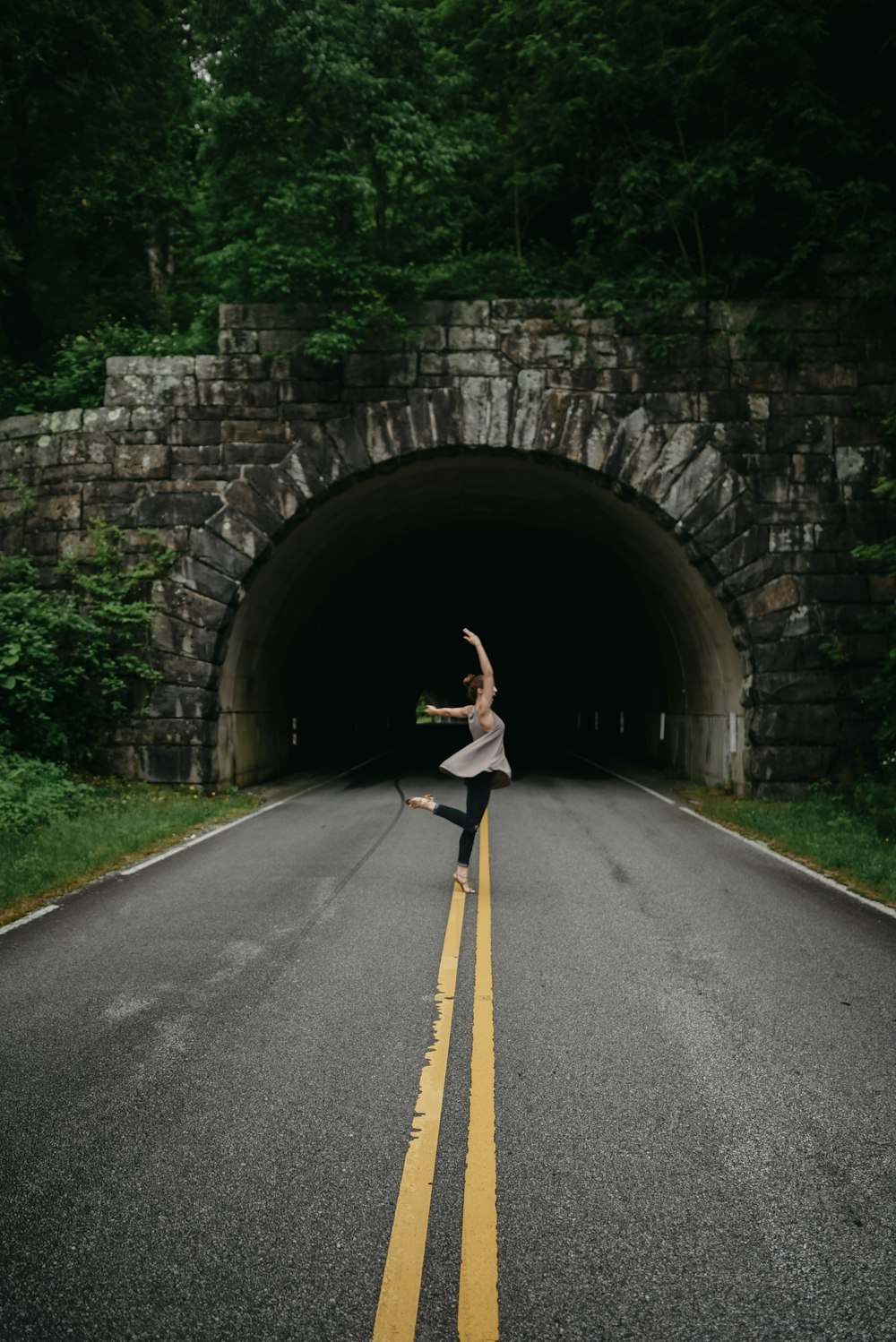 woman in ballet position nearby tunnel