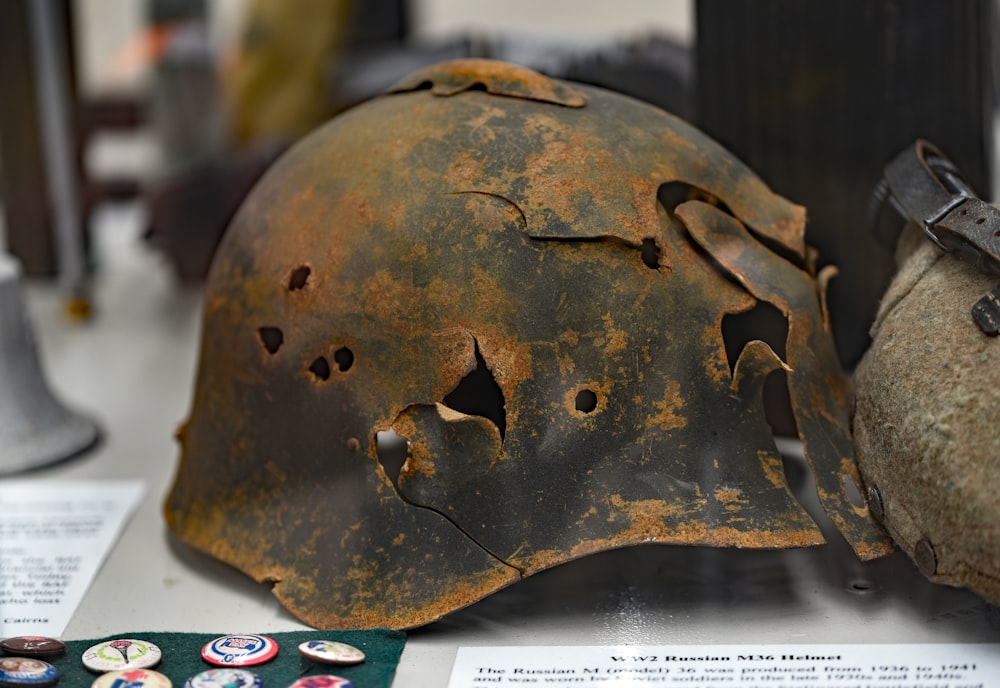 白い表面に穴の開いた錆びた兵士のヘルメット