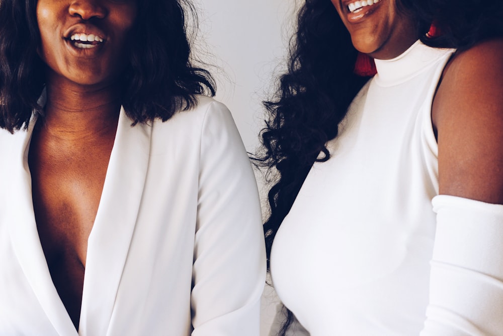 two women wearing white tops