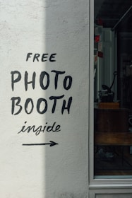 a sign on the side of a building that says free photo booth inside