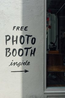 a sign on the side of a building that says free photo booth inside