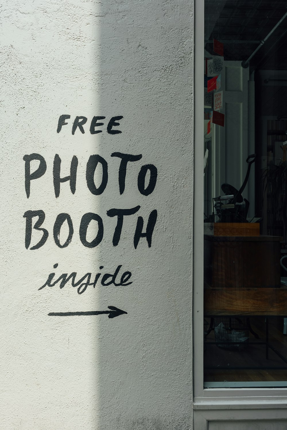 a sign on the side of a building that says free photo booth inside