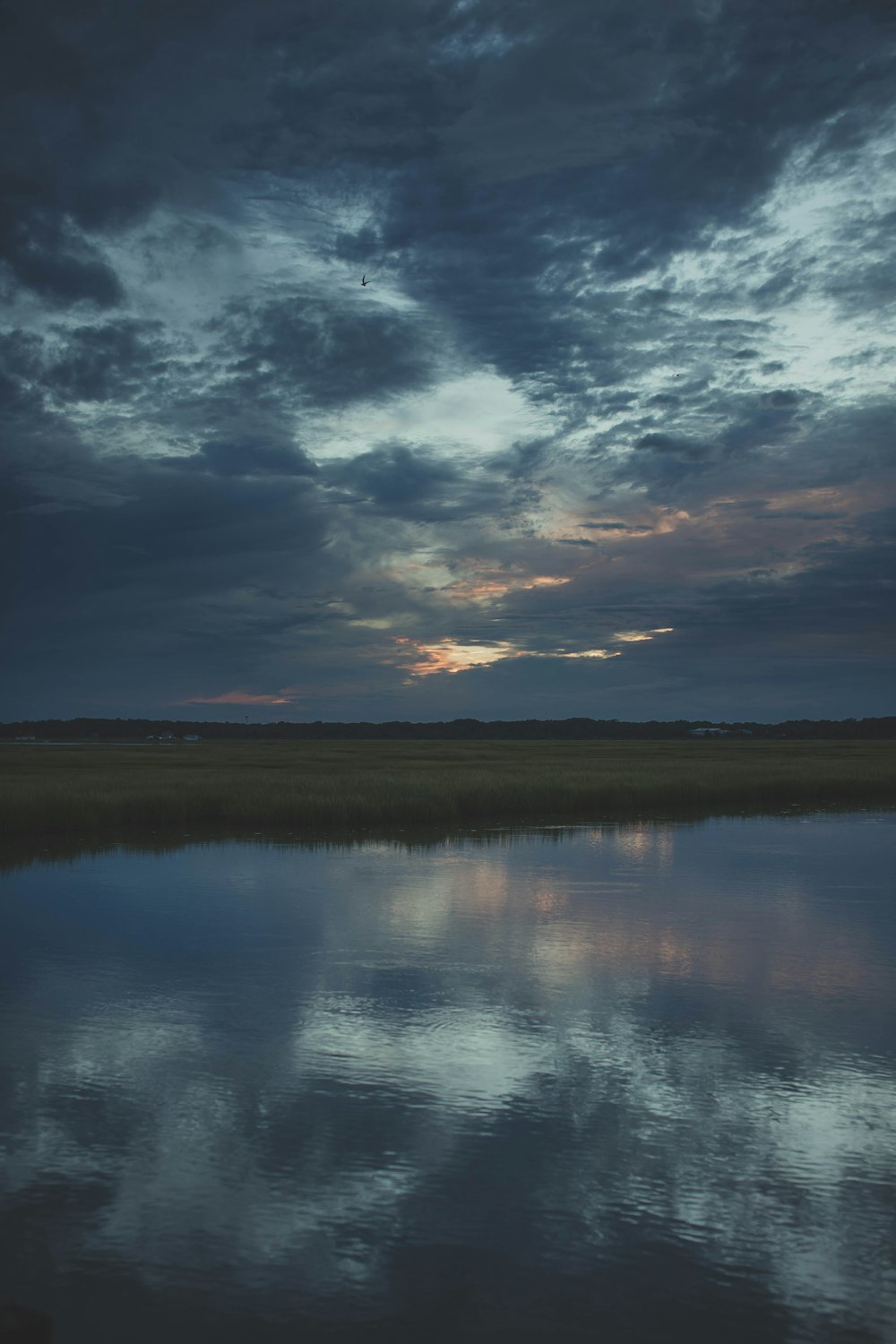 a body of water under a cloudy sky