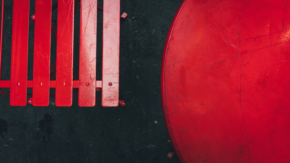 a close up of a red bench with bars on it