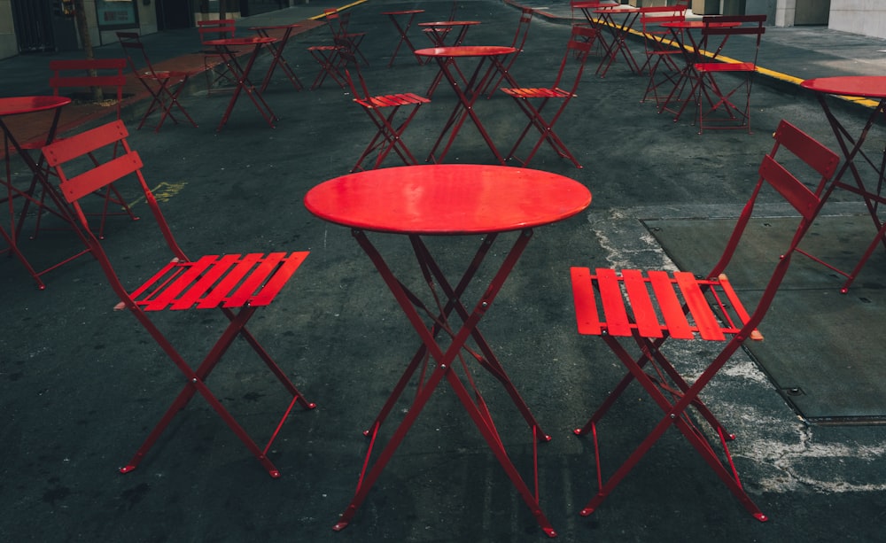 a row of red tables and chairs in a parking lot