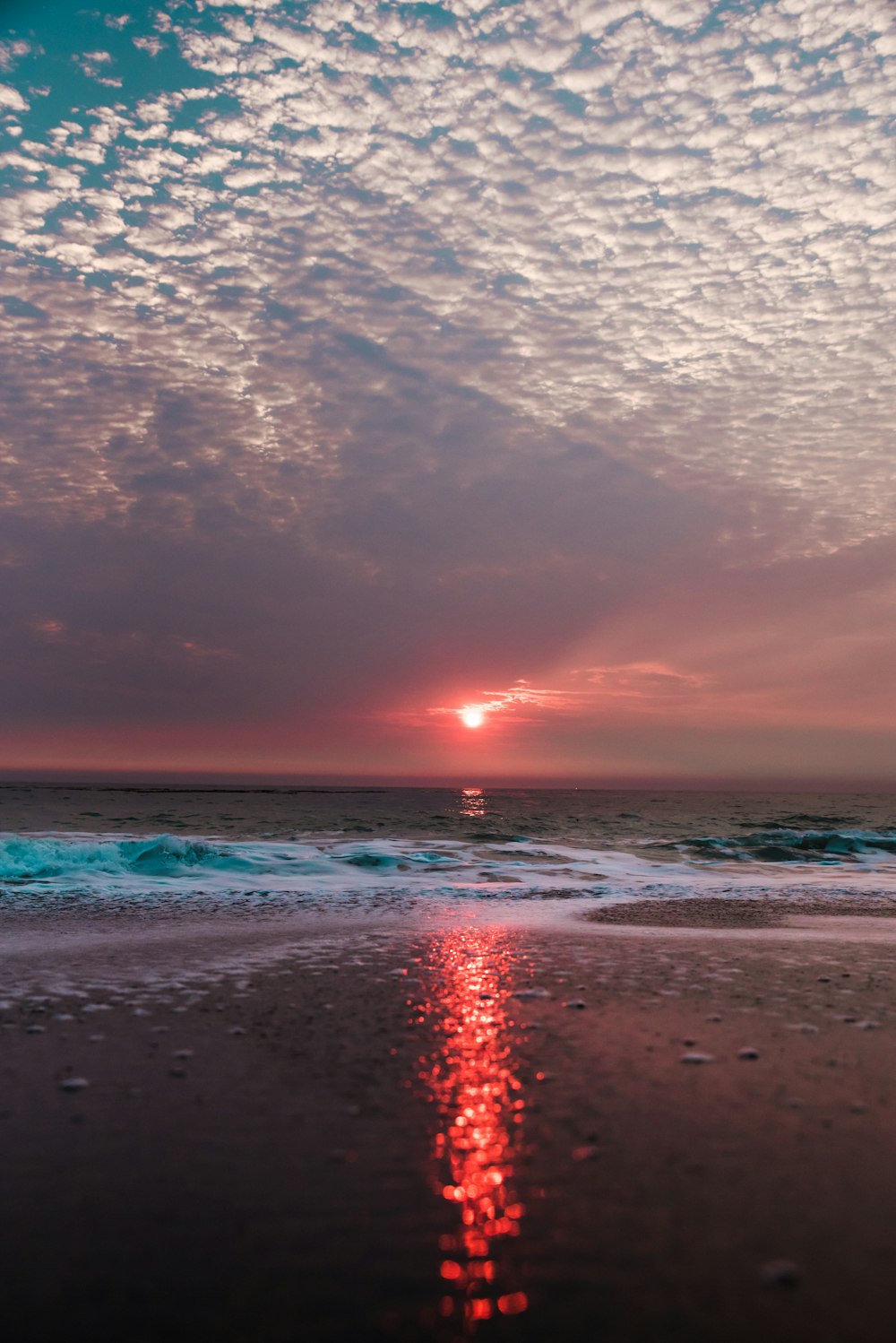 plage sous ciel nuageux au coucher du soleil