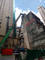Construction site with workers and cranes in an urban setting.