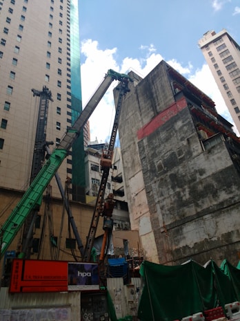 Modern residential buildings under construction with cranes in an urban environment.