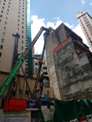 Construction site with workers and cranes in an urban setting.