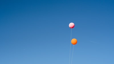 two orange and pink balloons string teams background