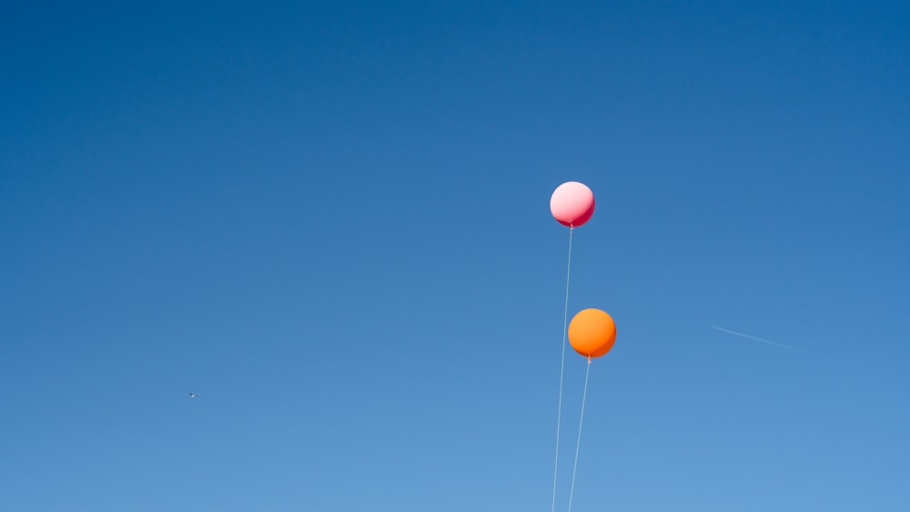 dos globos naranjas y rosas