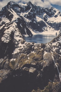 A scenic mountain view with snow-capped peaks and a clear lake.