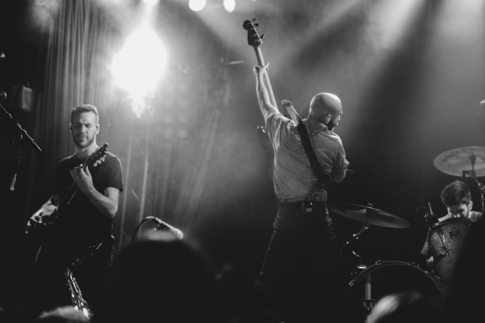 grayscale photo of band playing on stage