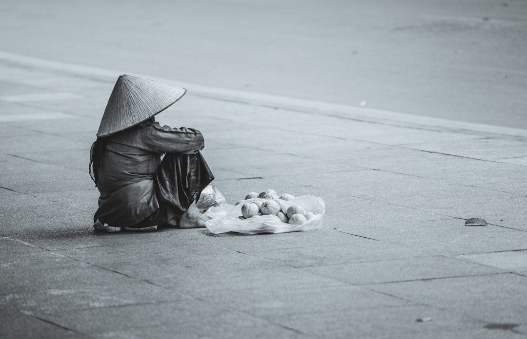 person sitting beside street, Asian rain hat