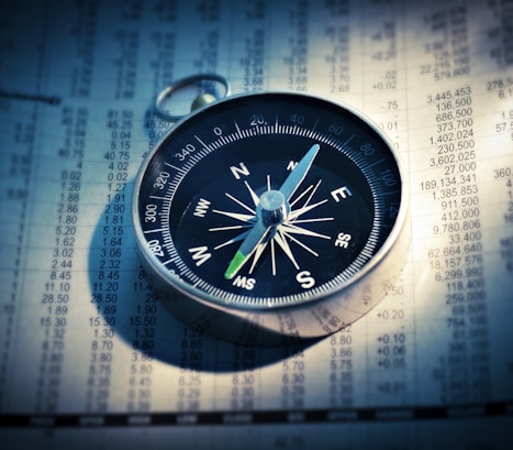 shallow focus photograph of black and gray compass