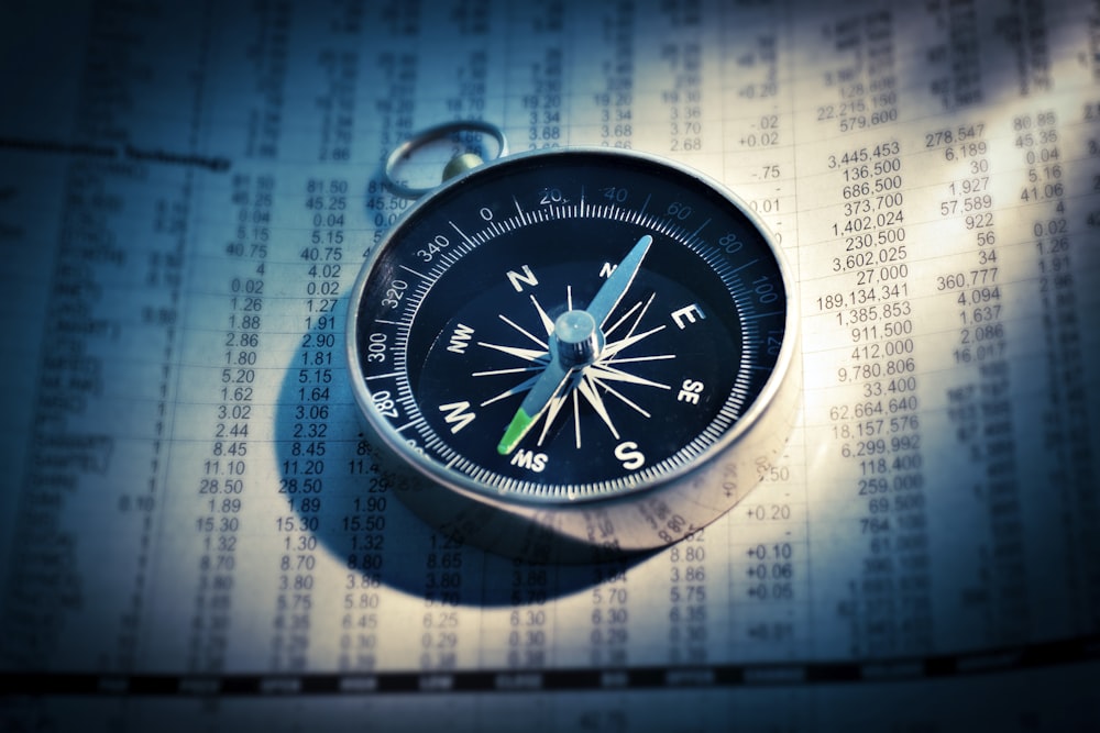 shallow focus photograph of black and gray compass