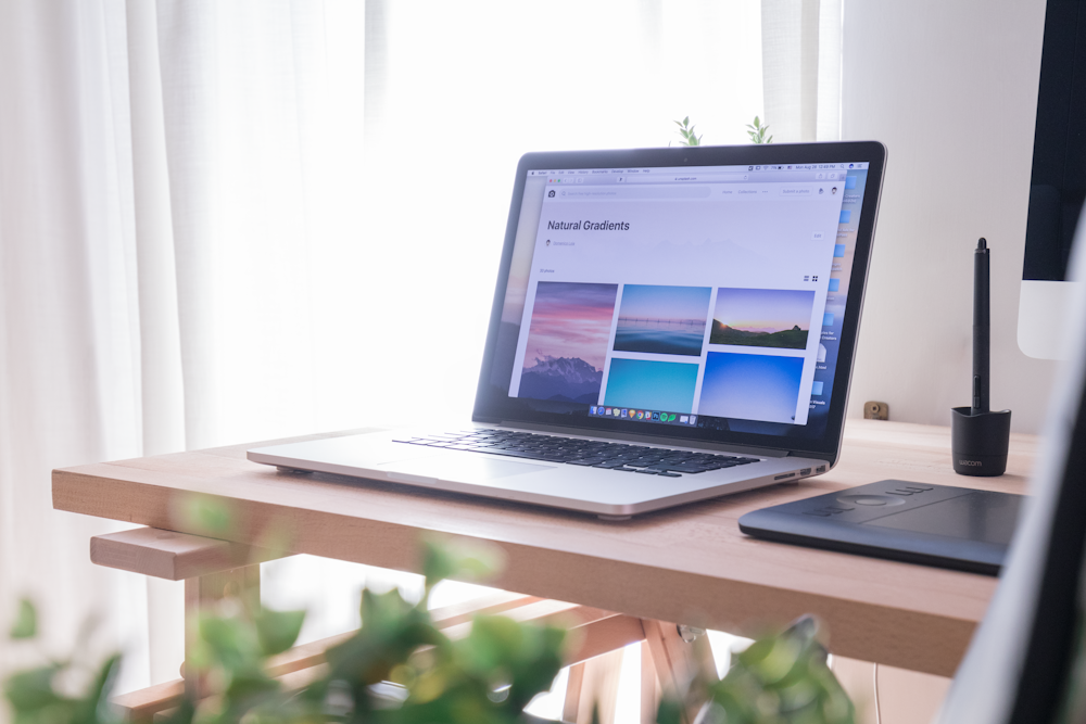 laptop cinza e preto aberto na mesa de madeira