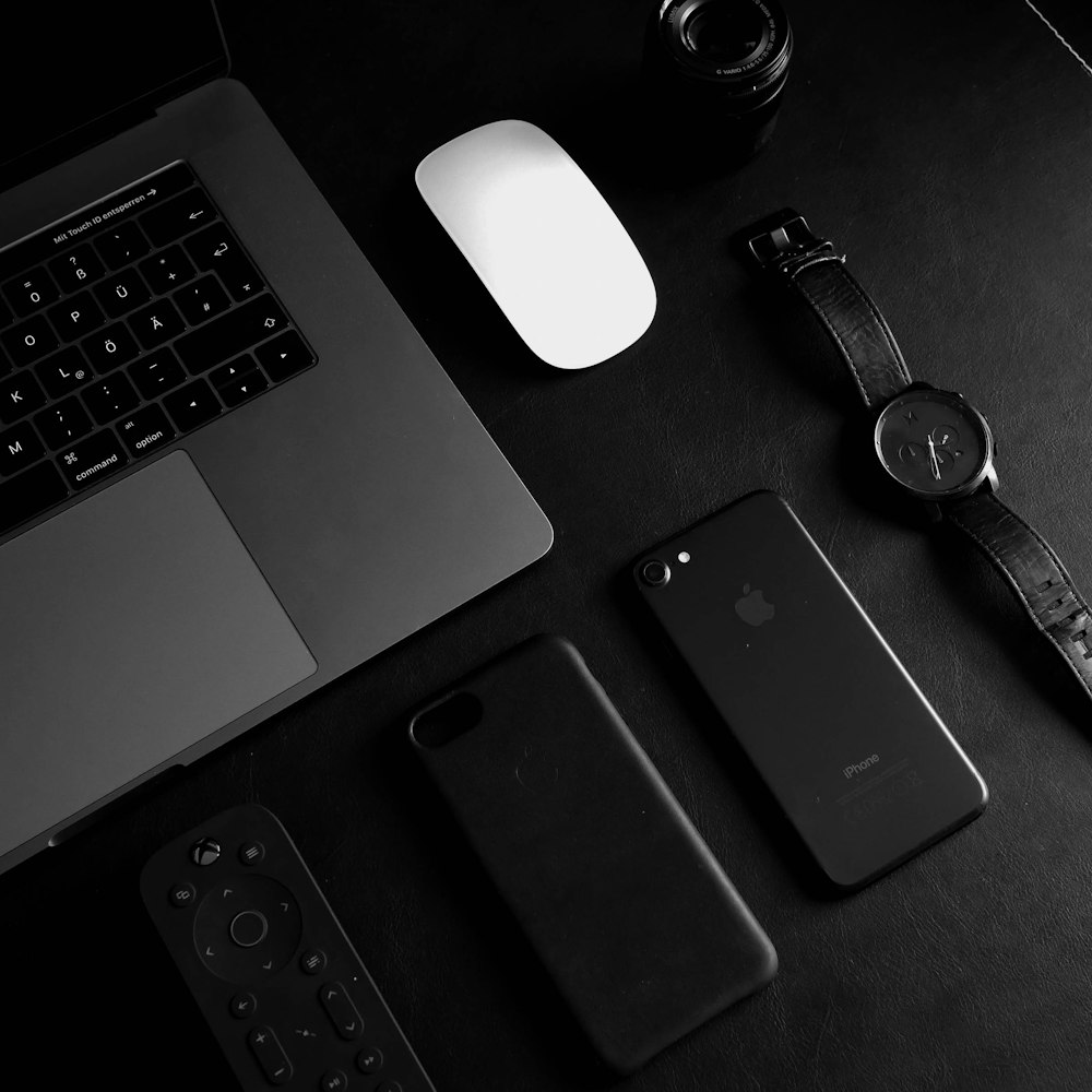 jet black iPhone 7 beside analog watch