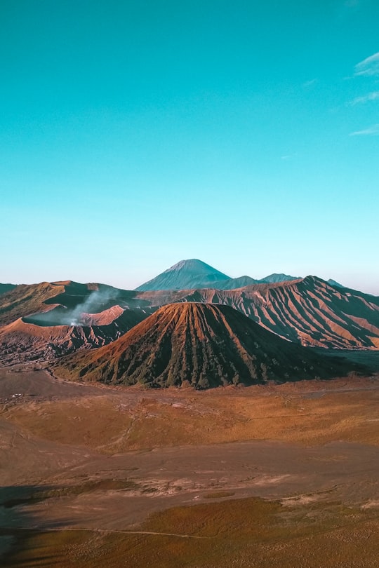 landscape photography of hill under blue sky in Bromo Tengger Semeru National Park Indonesia