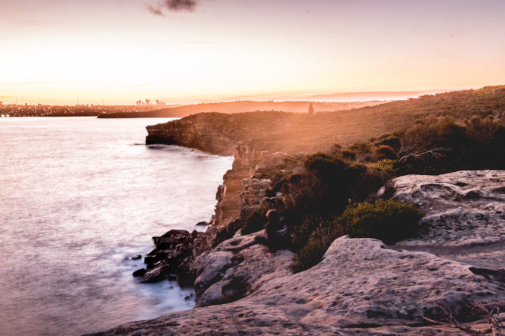 rock formation near body of water during golden hour