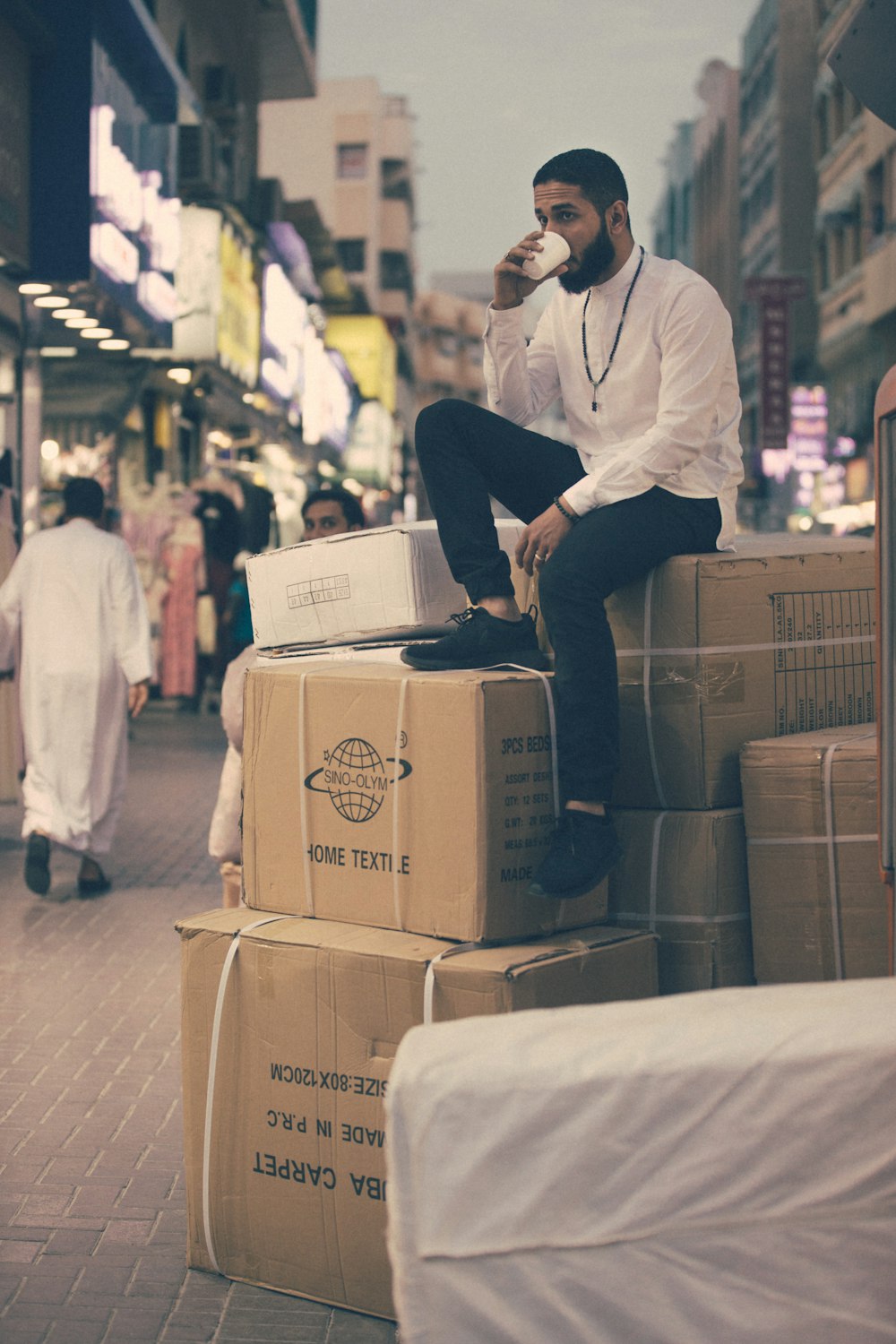 屋外の箱の上に座っている男