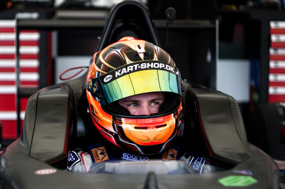 man riding sports car wearing helmet