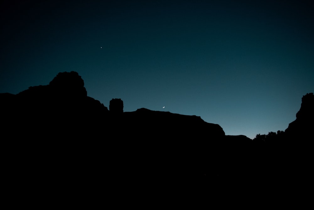 silhouette of mountains under clear sky