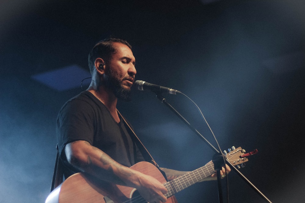 man playing guitar while singing