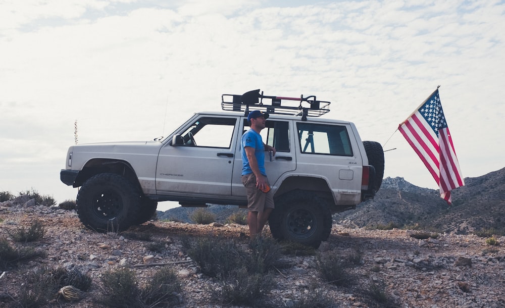 man standing beside vehicle