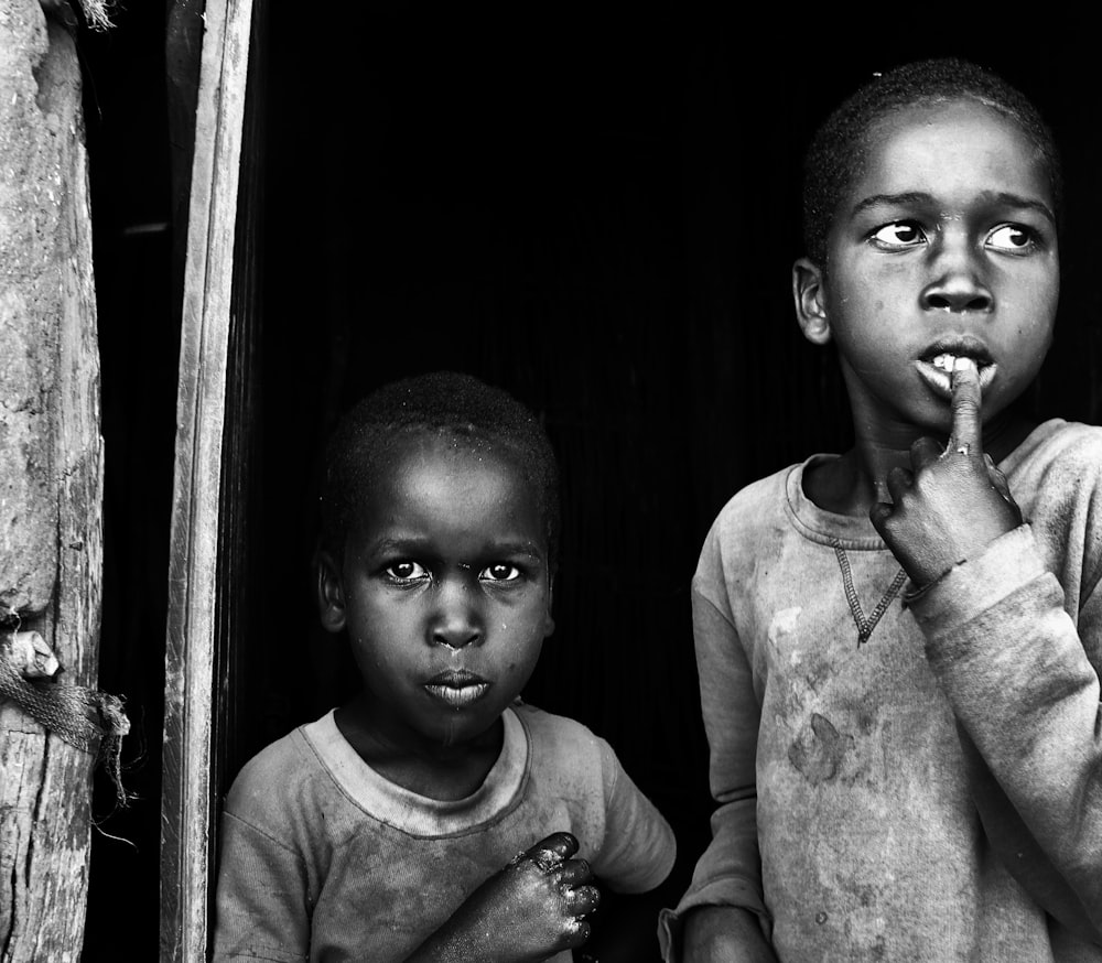 closeup photo of two children near wall