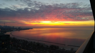 A vibrant sunset over the Miami skyline, reflecting off the water.