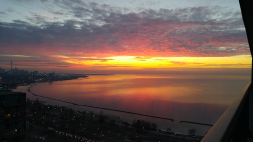 A vibrant sunset over the Miami skyline, reflecting off the water.