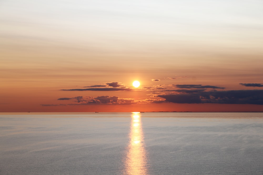 body of water under orange sky