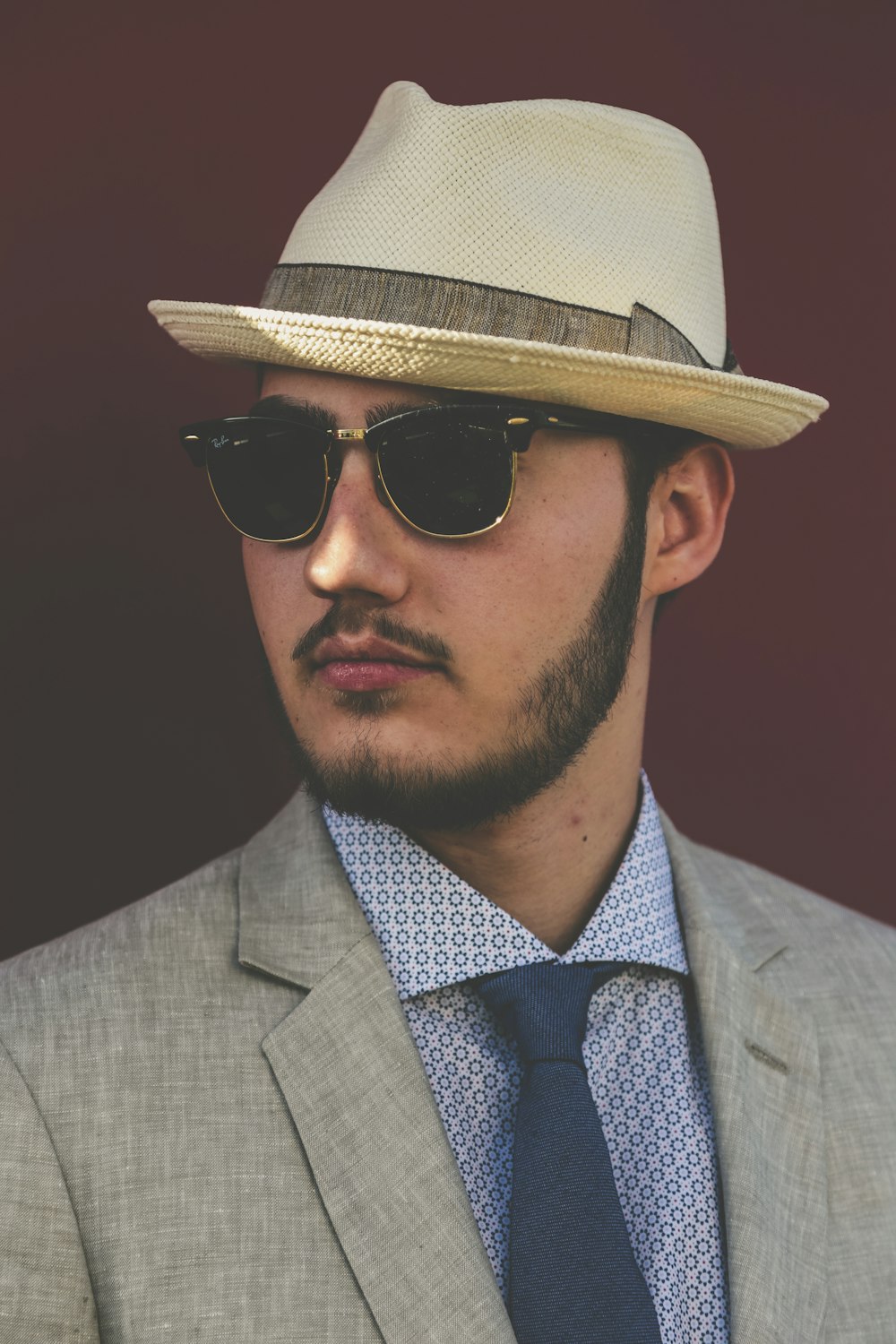 Hombre con abrigo gris y sombrero fedora beige