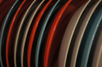 Rows of ceramic, stainless steel, and bamboo plates lined up in a bright factory.